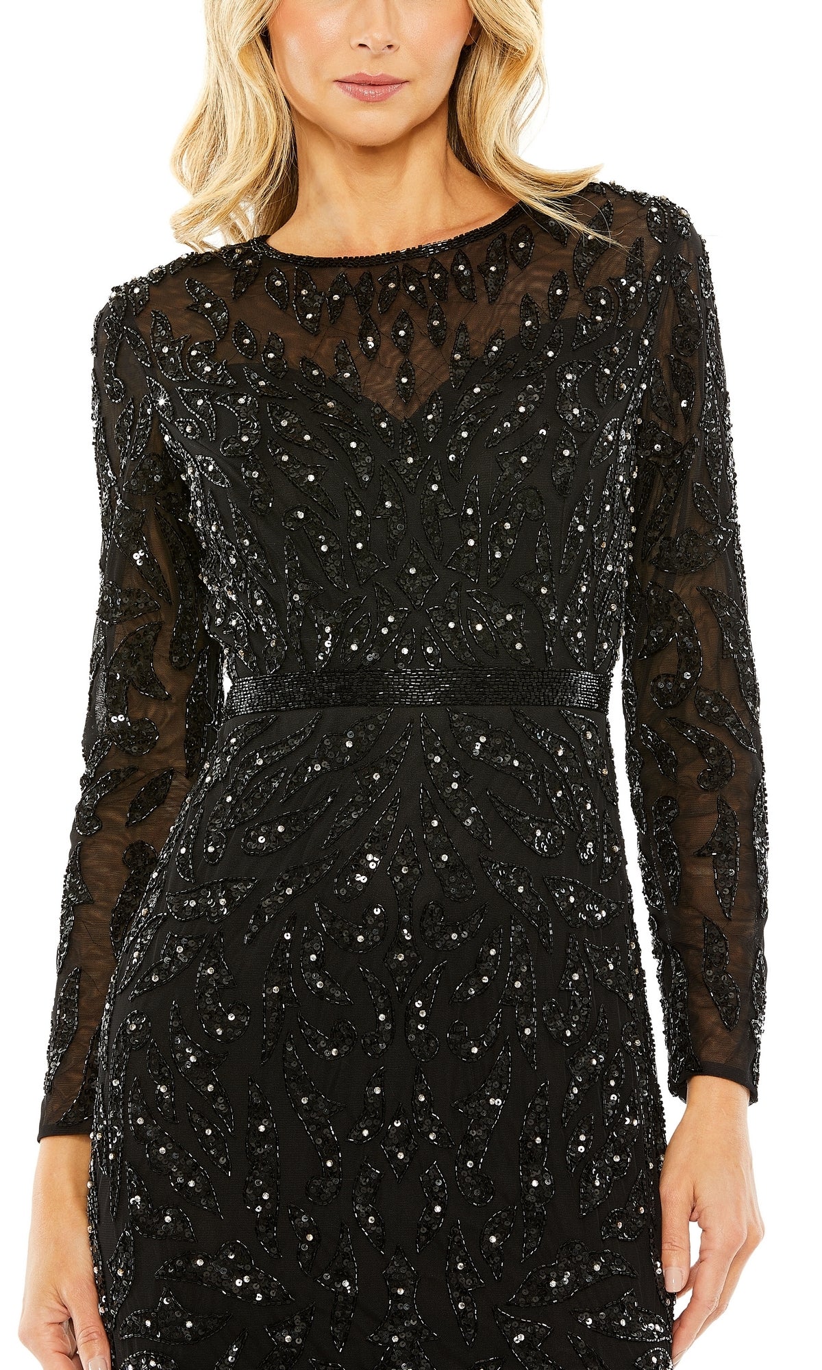 A woman wears the Mac Duggal 5124 Long Sleeve Sequin Formal Dress, a black sheer gown featuring intricate bead and sequin leaf patterns—ideal as a modest evening dress.